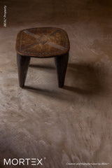 Mortex mineral skin floor finish in bronze tone with wooden stool